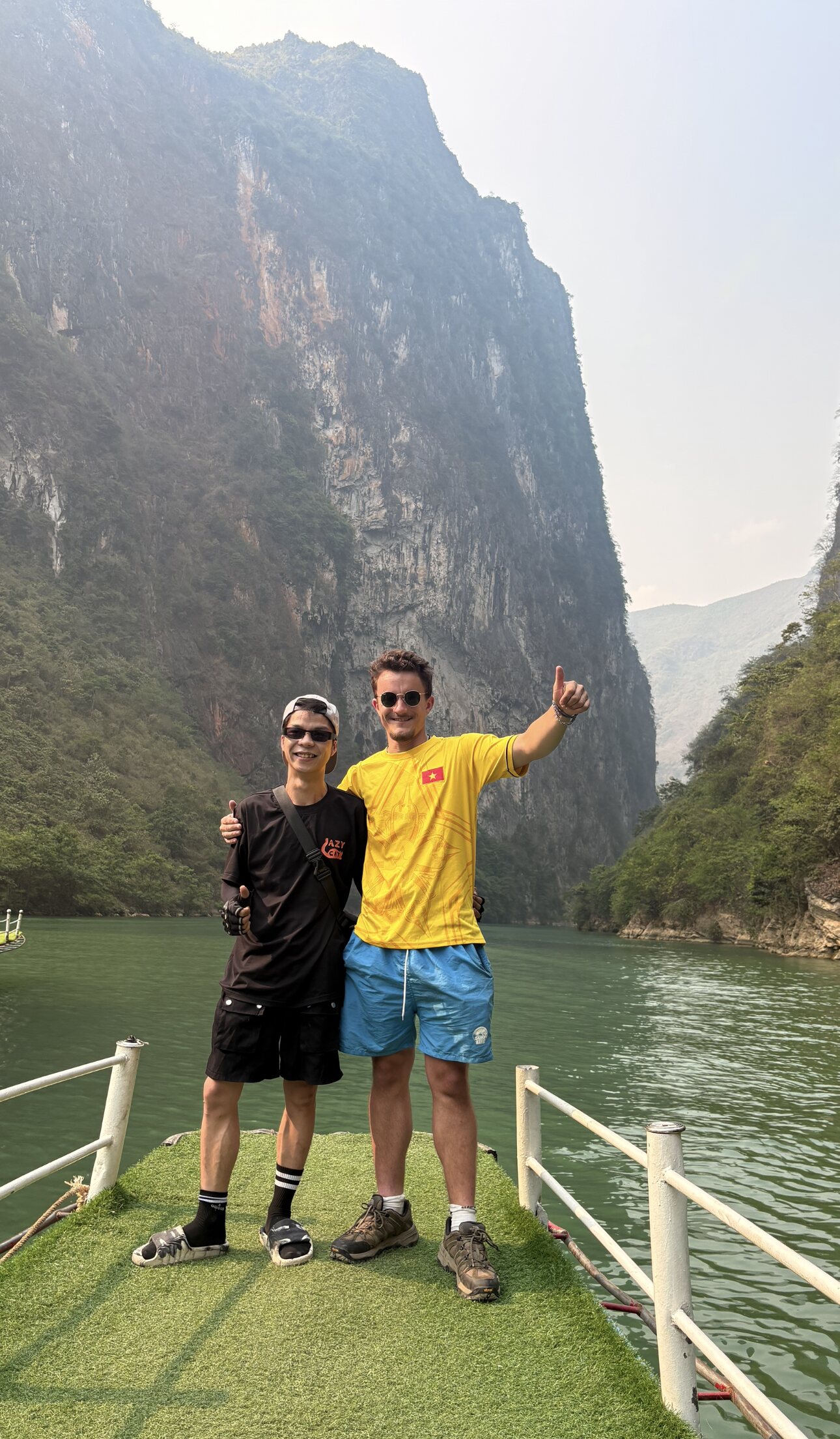 Ollie with a local guide beside limestone cliffs and water in Cao Bang, Vietnam